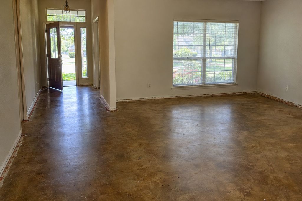 Older house hallway with carpet removed and the slab stained a warm brown